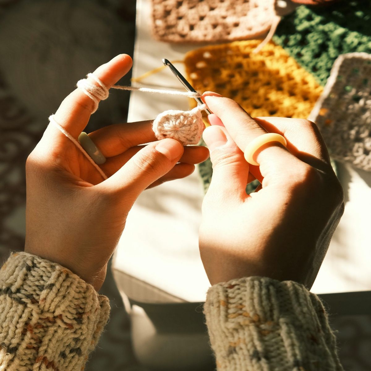 Gros plan sur des mains en train de crocheter, incarnant le geste artisanal