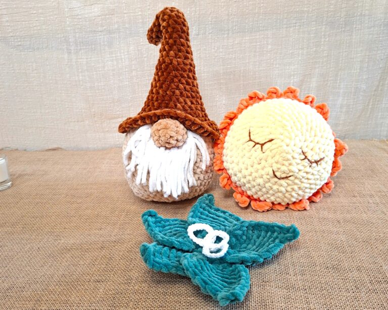 Trois Veilleurs d’Hiver crochetés : Naélis le gnome, Lumino la lumière ronde et Sélia la feuille turquoise en chenille, posés sur une toile de jute.