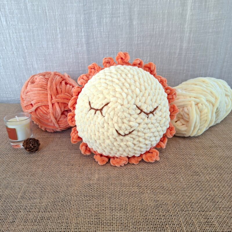Boule lumineuse crochetée en fil chenille jaune et pêche, visage serein brodé à la main, création artisanale Clairimagine - Lumino, collection Les Veilleurs d’Hiver.